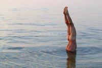 naked-man-doing-a-handstand-underwater-in-a-bay.jpg